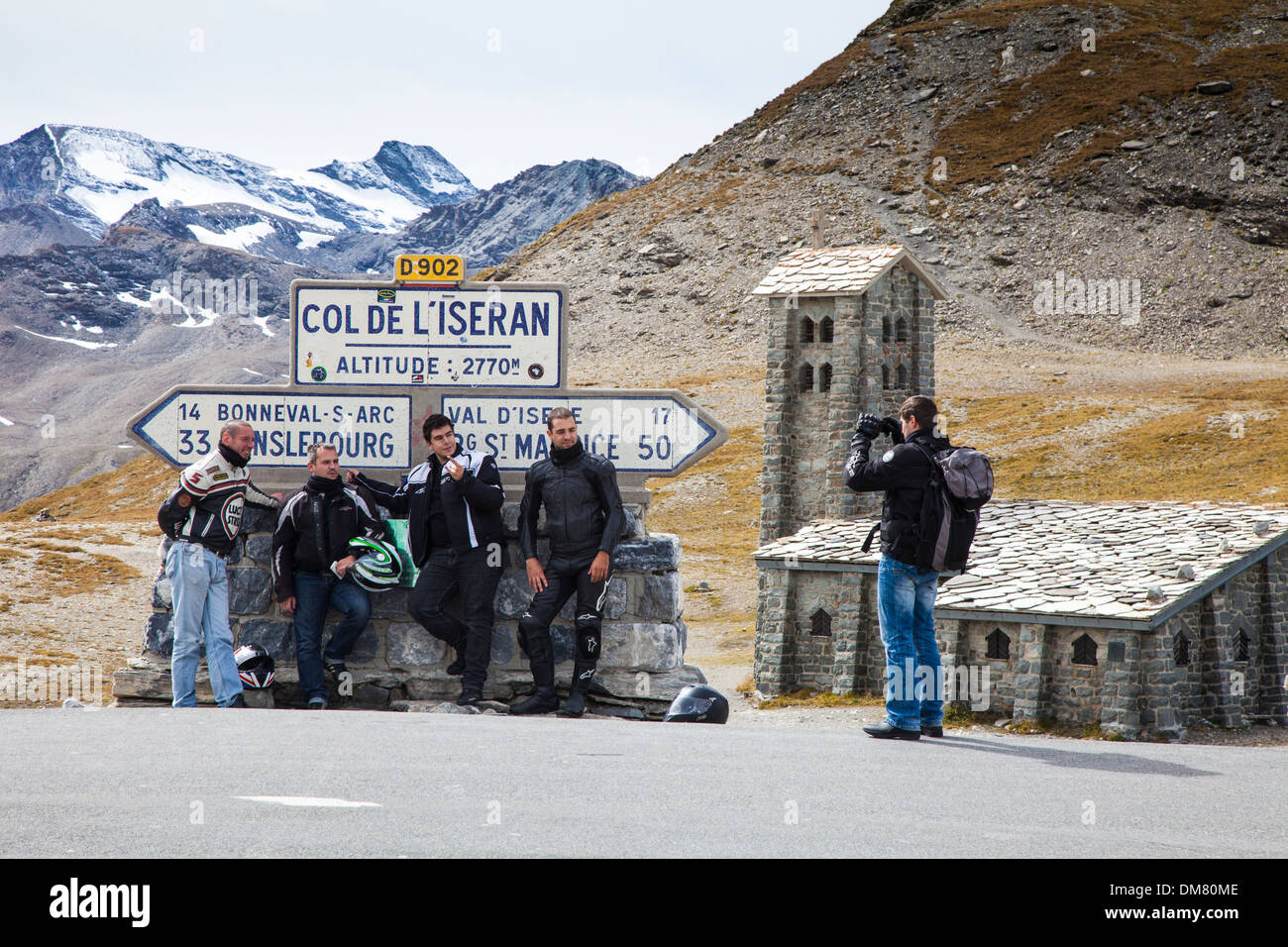 Motociclisti pongono accanto al Col d'Iseran mountain pass segno, Savoie, Francia Foto Stock