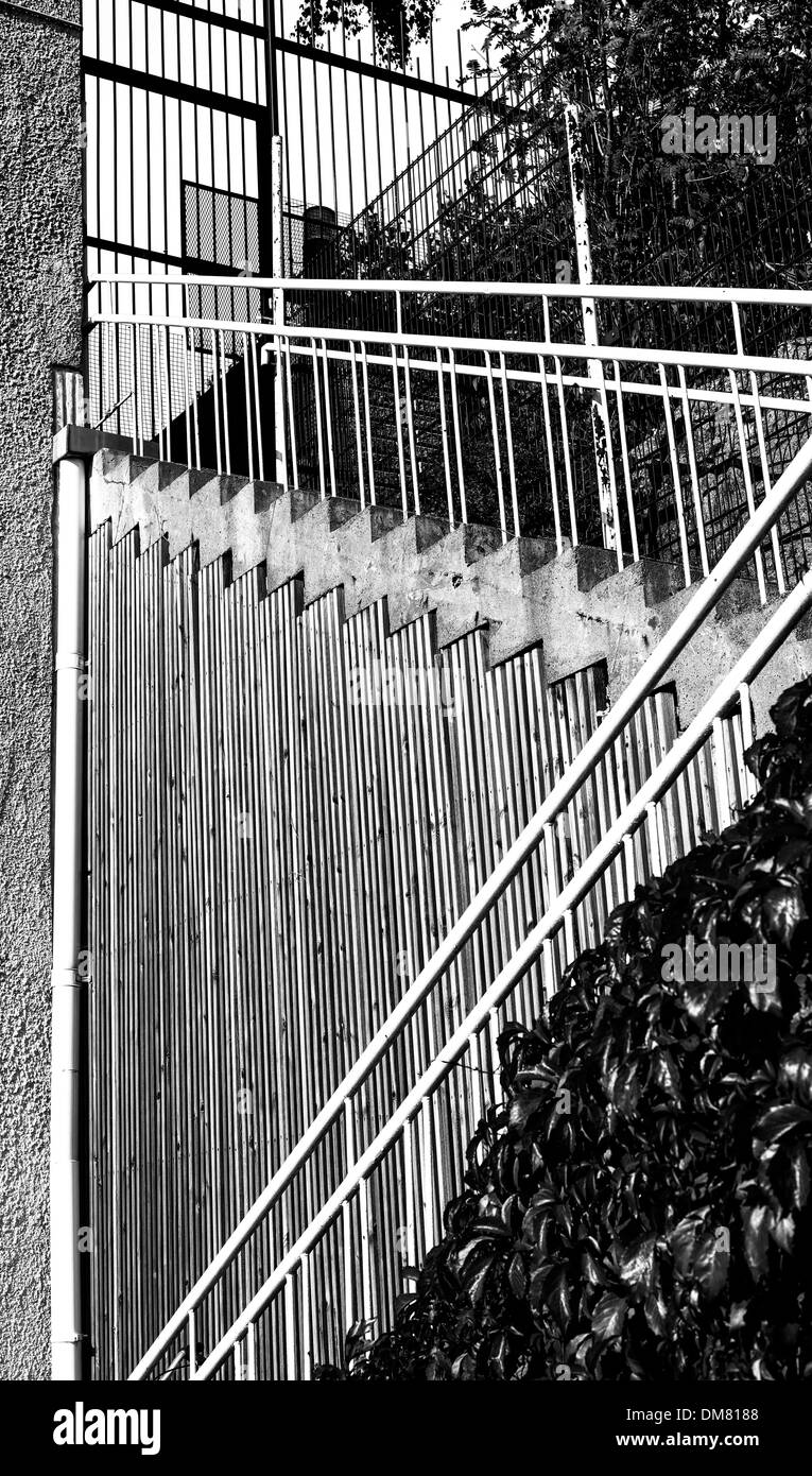 Display grafico di linee da un calcestruzzo una scalinata che conduce fino a una recinzione Foto Stock