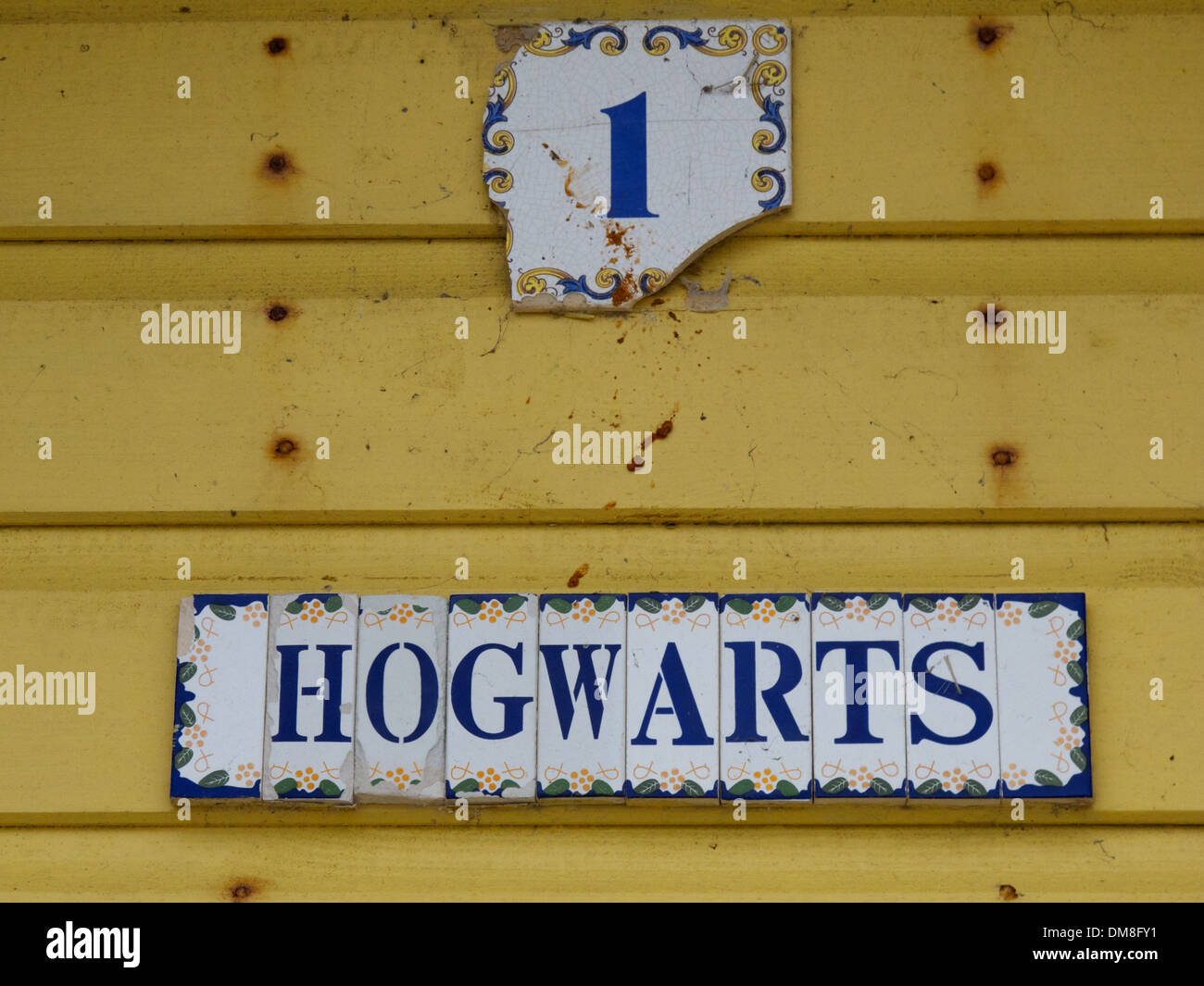 Il numero 1 e il segno di Hogwarts su un giallo beach hut a Sheringham, North Norfolk, Inghilterra Foto Stock