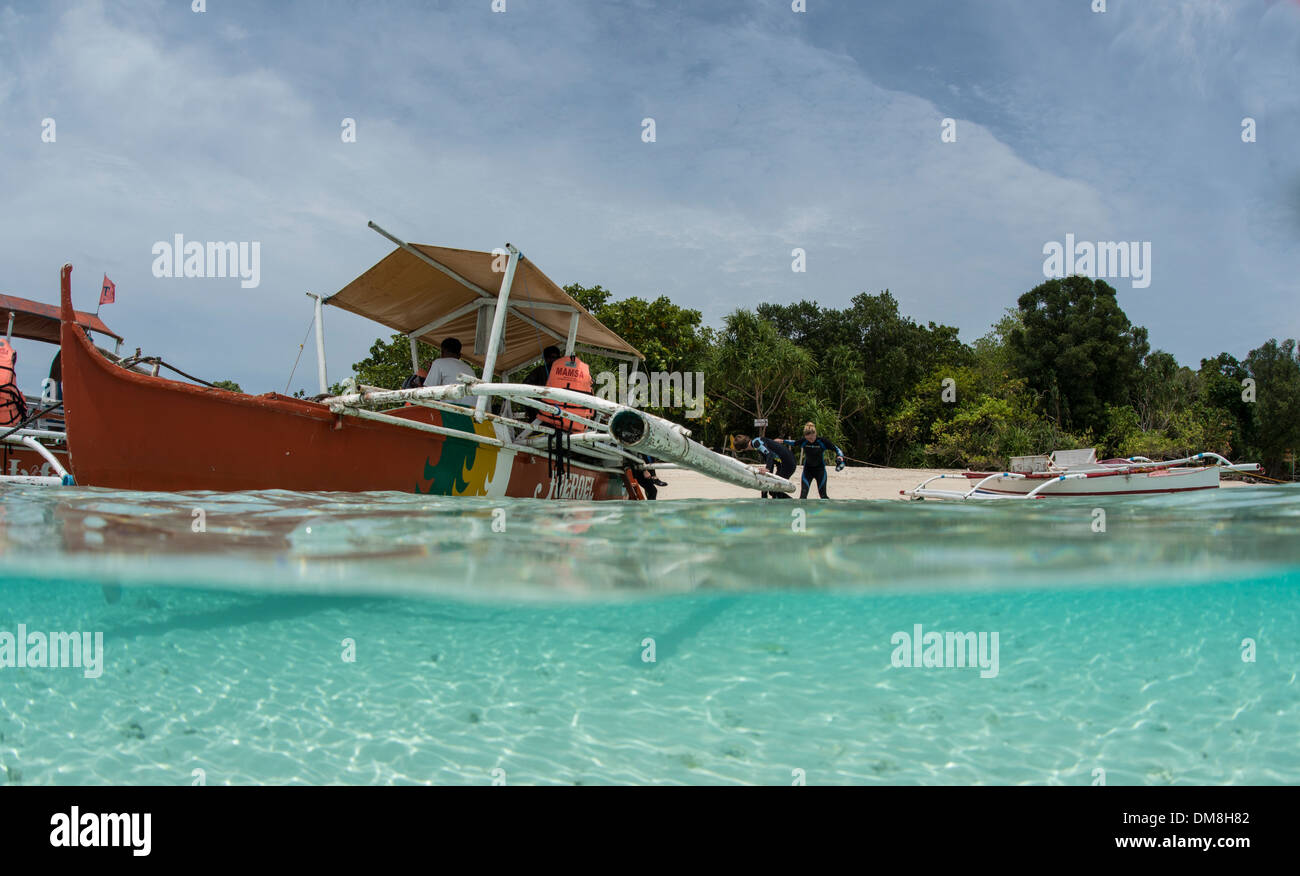 Split Screen di una barca e i sommozzatori sulla spiaggia di Paradise Island Foto Stock