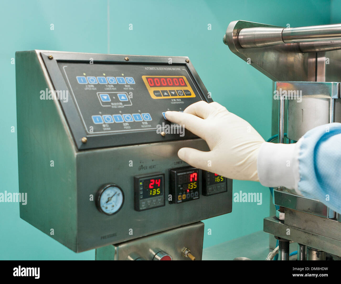 Bliser macchina impacchettatrice telecomando e mano umana in guanti Foto Stock