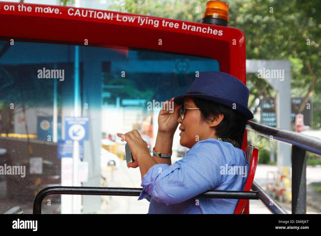 La donna che indossa turistica hat, equitazione HiPPO bus e la revisione di una foto della fotocamera. Singapore. Foto Stock