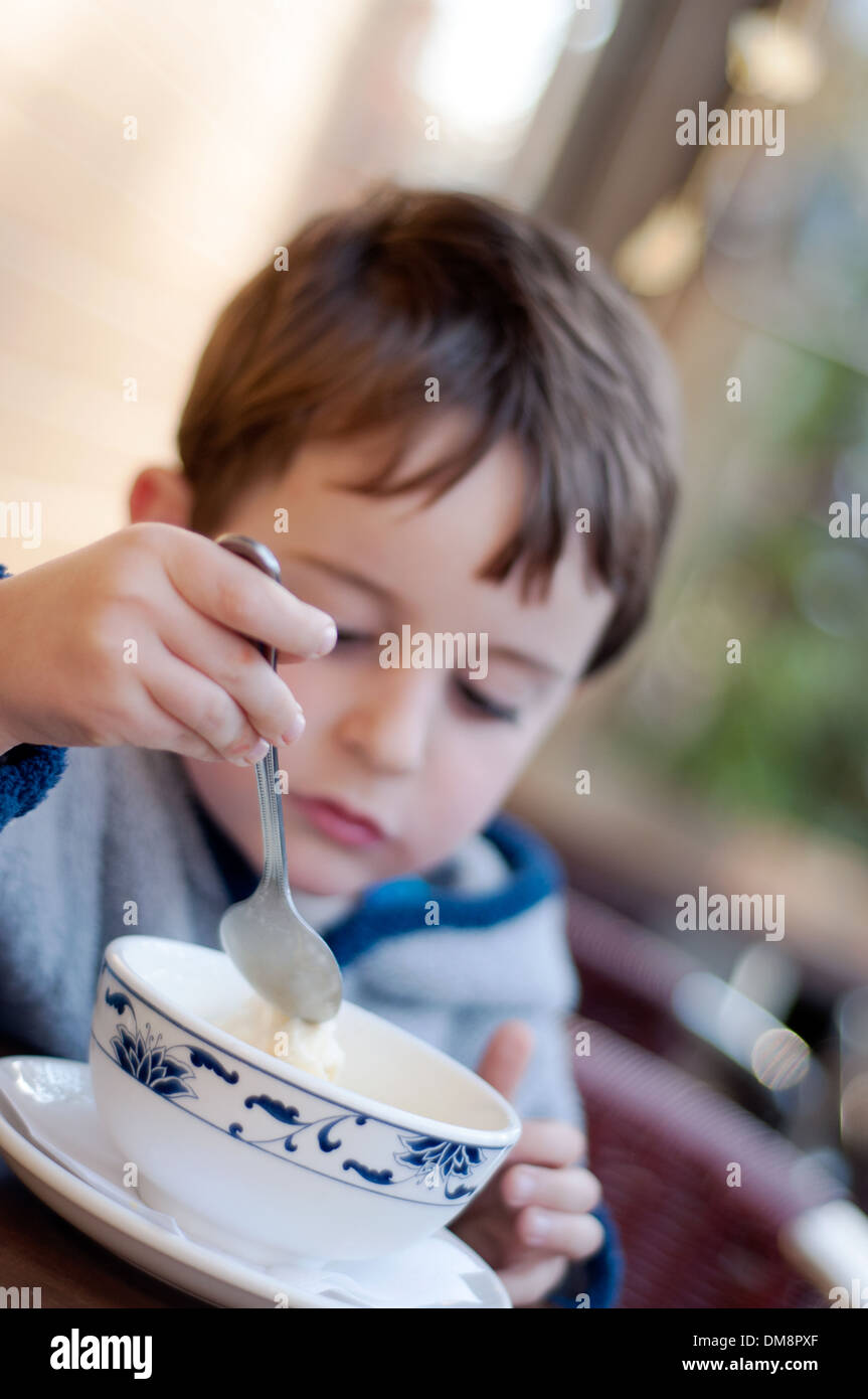 Quattro anni vecchio ragazzo a mangiare il gelato Foto Stock
