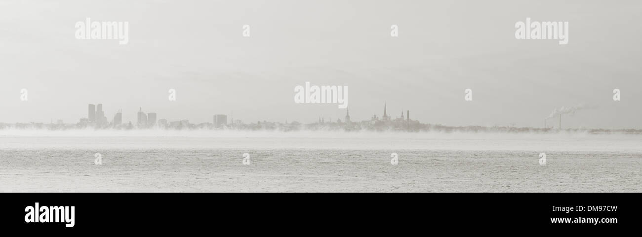 Panorama della città di silhouette di Tallinn, Estonia, nella nebbia dietro il mare Foto Stock