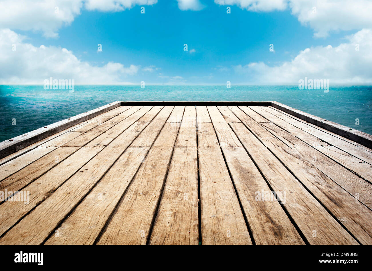 Legno luminoso superficie decking sotto uno sfondo con cielo nuvoloso Foto Stock