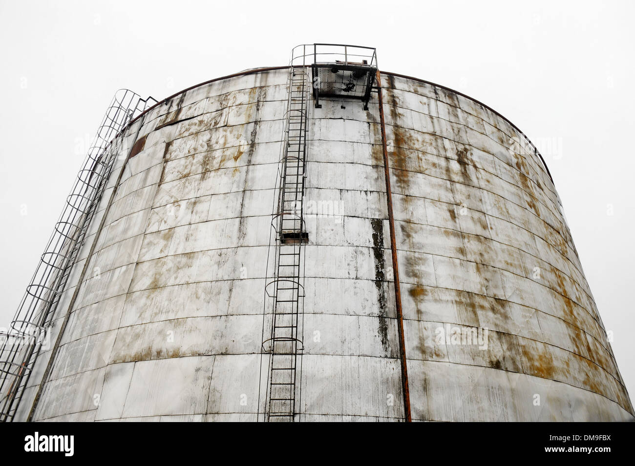 Grande olio industriale serbatoio di stoccaggio con cielo grigio sullo sfondo Foto Stock