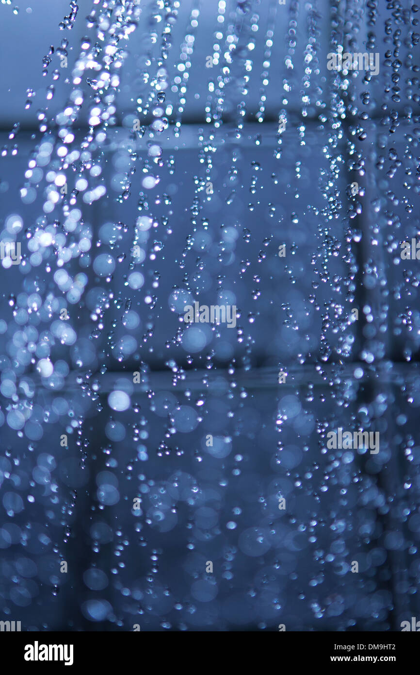 Esecuzione di acqua proveniente da una testa di doccia con gocce d'acqua Foto Stock