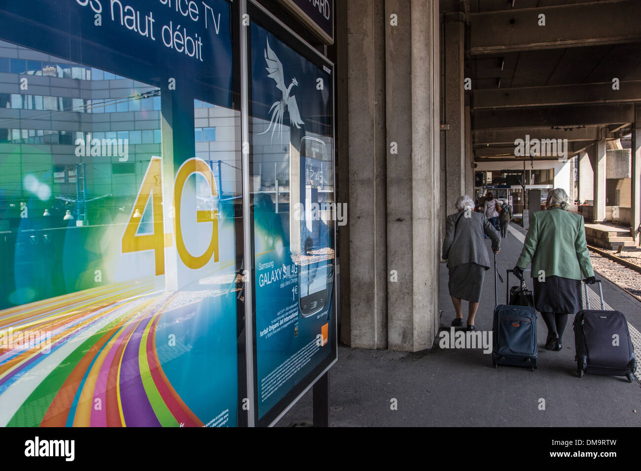 Pubblicita per 4G ULTRA-ACCESSO A INTERNET A BANDA LARGA e la vecchia donna sulla banchina di MONTPARNASSE-VAUGIRARD STATION, 15esimo arrondissement, Parigi, Francia Foto Stock