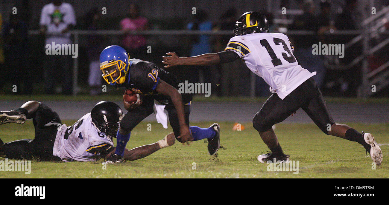 SCOTT KEELER | Orari.SP 309662 chiglia FOOTBALL (09/04/2009) ST. Pietroburgo 15. Centro- Gibbs High School quarterback Joshua Rembert, (12), viene pressurizzato e fermato da Lakewood High School difesa Dante Fowler, (6), sinistra e Bar EE Boyd, (13), nel quarto trimestre a Gibbs High School a San Pietroburgo. [SCOTT KEELER, volte] (credito Immagine: © San Pietroburgo volte/ZUMA Press) Foto Stock