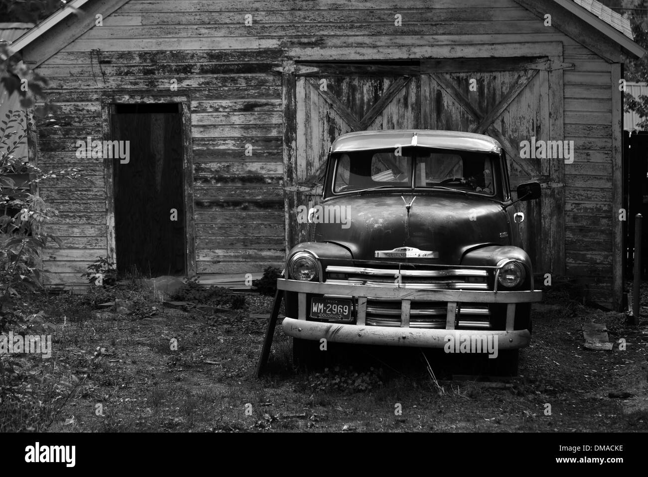 Abbandonata e in disuso Chevrolet pickup truck parcheggiato al di fuori di una tettoia in legno, Colorado, STATI UNITI D'AMERICA Foto Stock