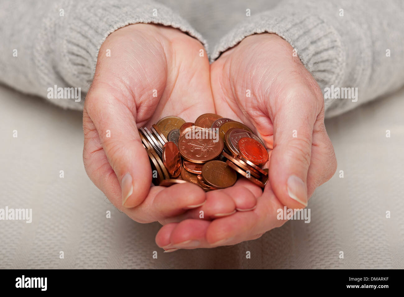 Primo piano di uomo persona mani in possesso inglese costo di vita pagamento denaro piccolo cambio moneta monete Inghilterra Regno Unito GB Gran Bretagna Foto Stock