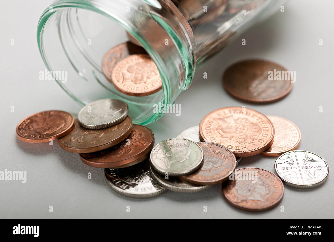 Primo piano di monete in contanti inglesi e marmellata Jar Inghilterra Regno Unito GB Gran Bretagna Foto Stock