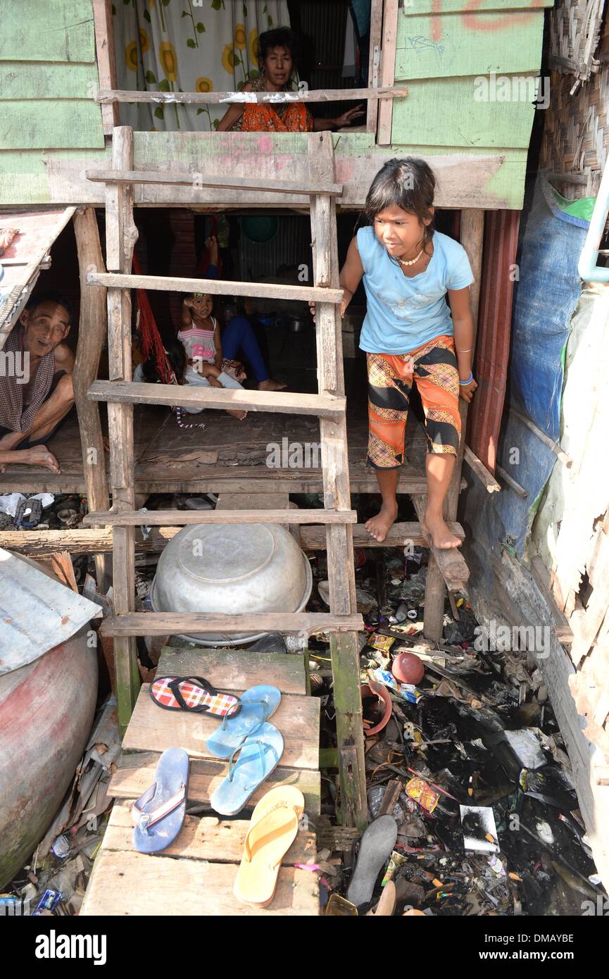 Phnom Penh Cambogia. Decimo Dec, 2013. Una ragazza esce da una capanna in baraccopoli 'Andong Bei Village' in Phnom Penh Cambogia, 10 dicembre 2013. La Cambogia è uno dei venti paesi con i più alti tassi di malnutrizione tra i bambini. Circa 670.000 orfani vive in Cambogia. Ogni 22 bambino muore nel primo anno di vita. Più di un terzo della popolazione vive con meno di un dollaro al giorno. Foto: Jens Kalaene/dpa/Alamy Live News Foto Stock