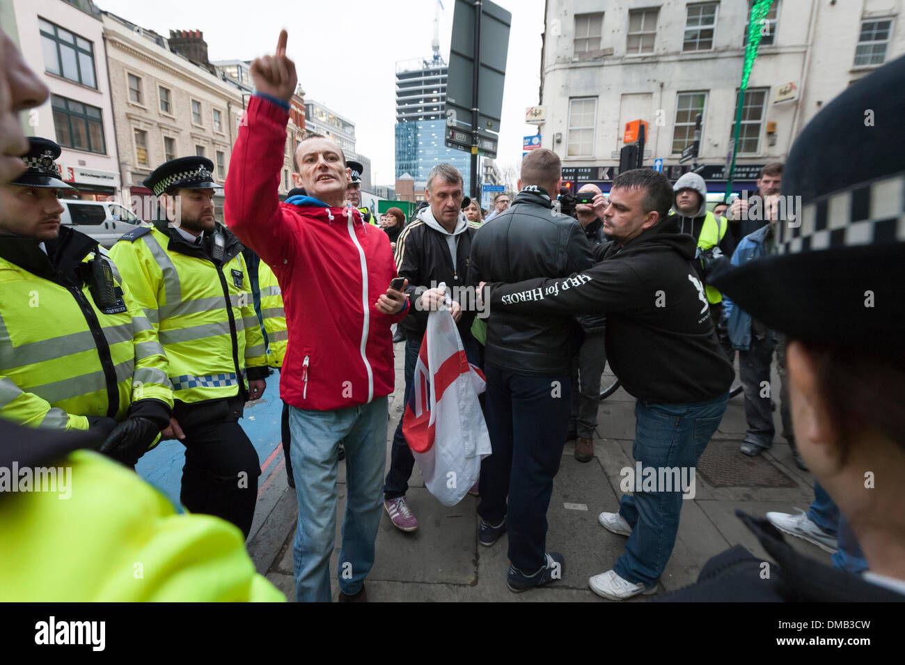 Brick Lane, Londra, Regno Unito. 13 dicembre, 2013. Gruppo musulmano "Sharia" Progetto mirato i negozi per la vendita di alcol e festaioli di Brick Lane. Il gruppo guidato da predicatore islamista, Anjem Choudary, è entrato in contatto con un gruppo di "Patrioti" e a destra dell' affiliato attivisti che hanno espresso il loro parere. Credito: Lee Thomas/Alamy Live News Foto Stock