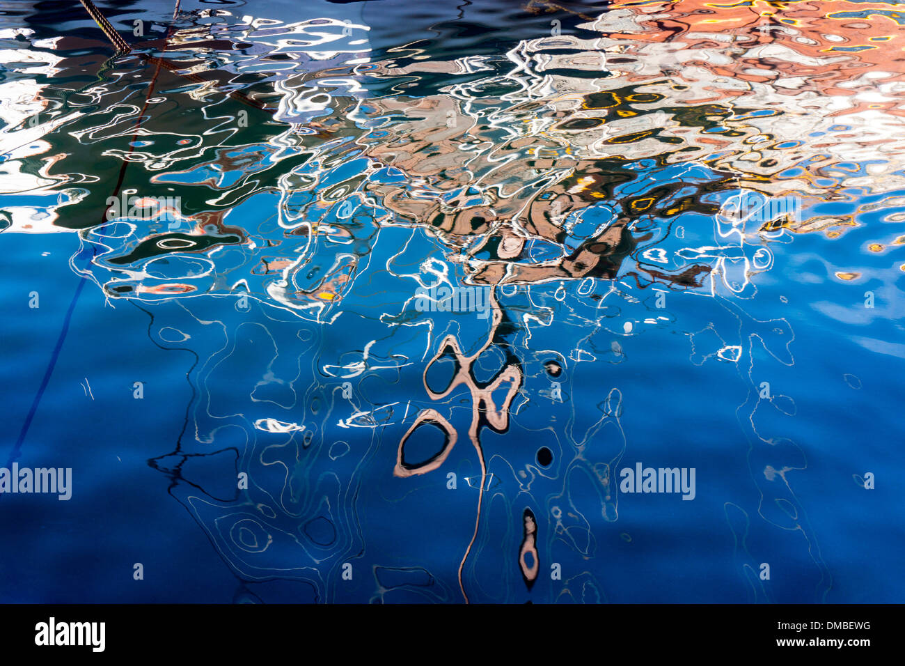 Le riflessioni della barca in acqua blu, increspature, calma Foto Stock