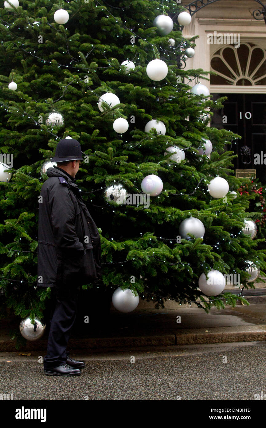 Westminster London,13 dicembre 2013. Un poliziotto sta in piedi di fronte ad un Natale al di fuori dei Primi Ministri residence al numero 10 di Downing Street. La struttura ad albero è stato scelto in un albero nazionale concorso vinto da Oxfordshire produttore Andrew Ingram Credito: amer ghazzal/Alamy Live News Foto Stock