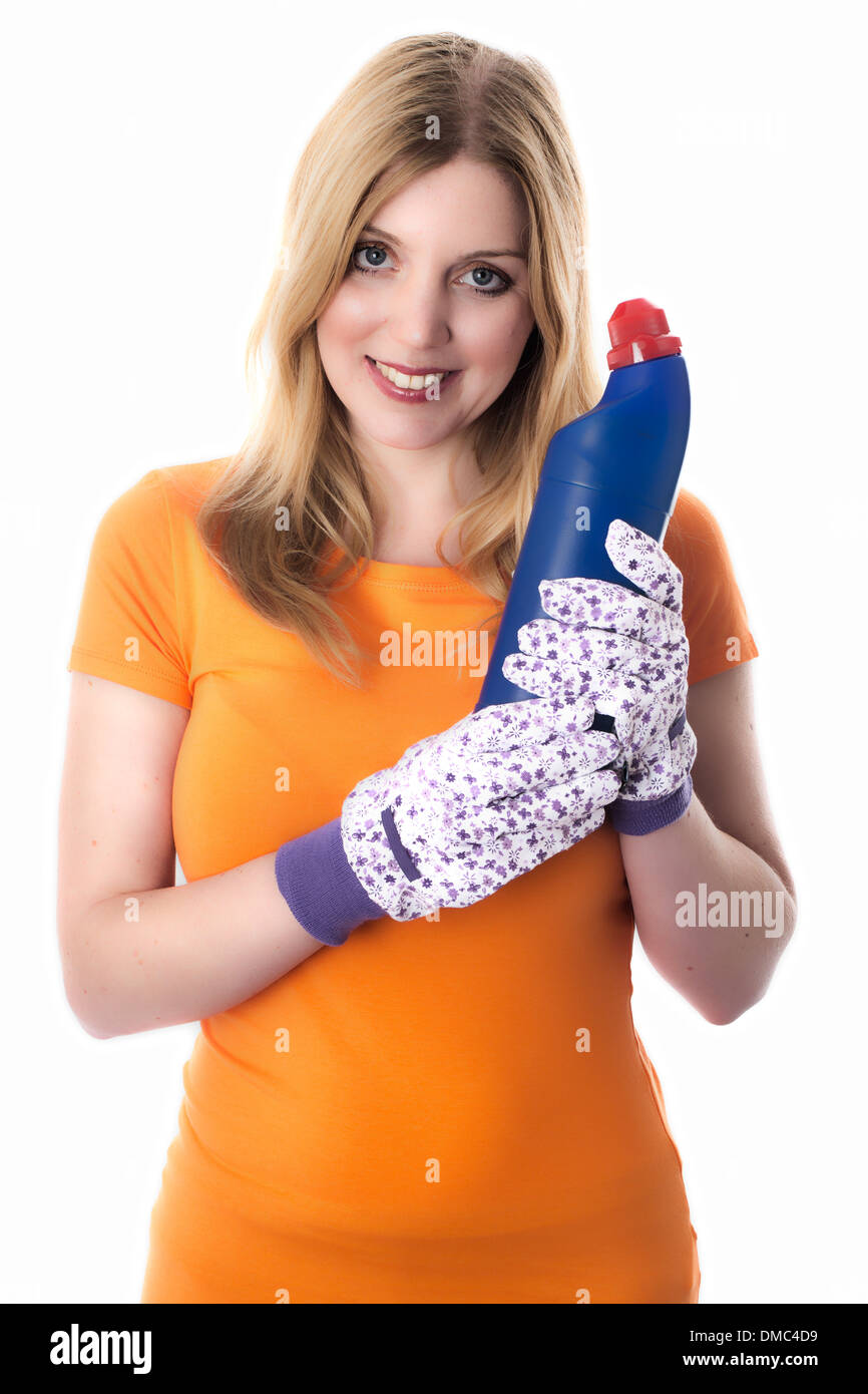 Giovane donna casalinga o indossando guanti di protezione tenendo una bottiglia di pulizia candeggina per sanificare elettrodomestici come WC e lavandini Foto Stock