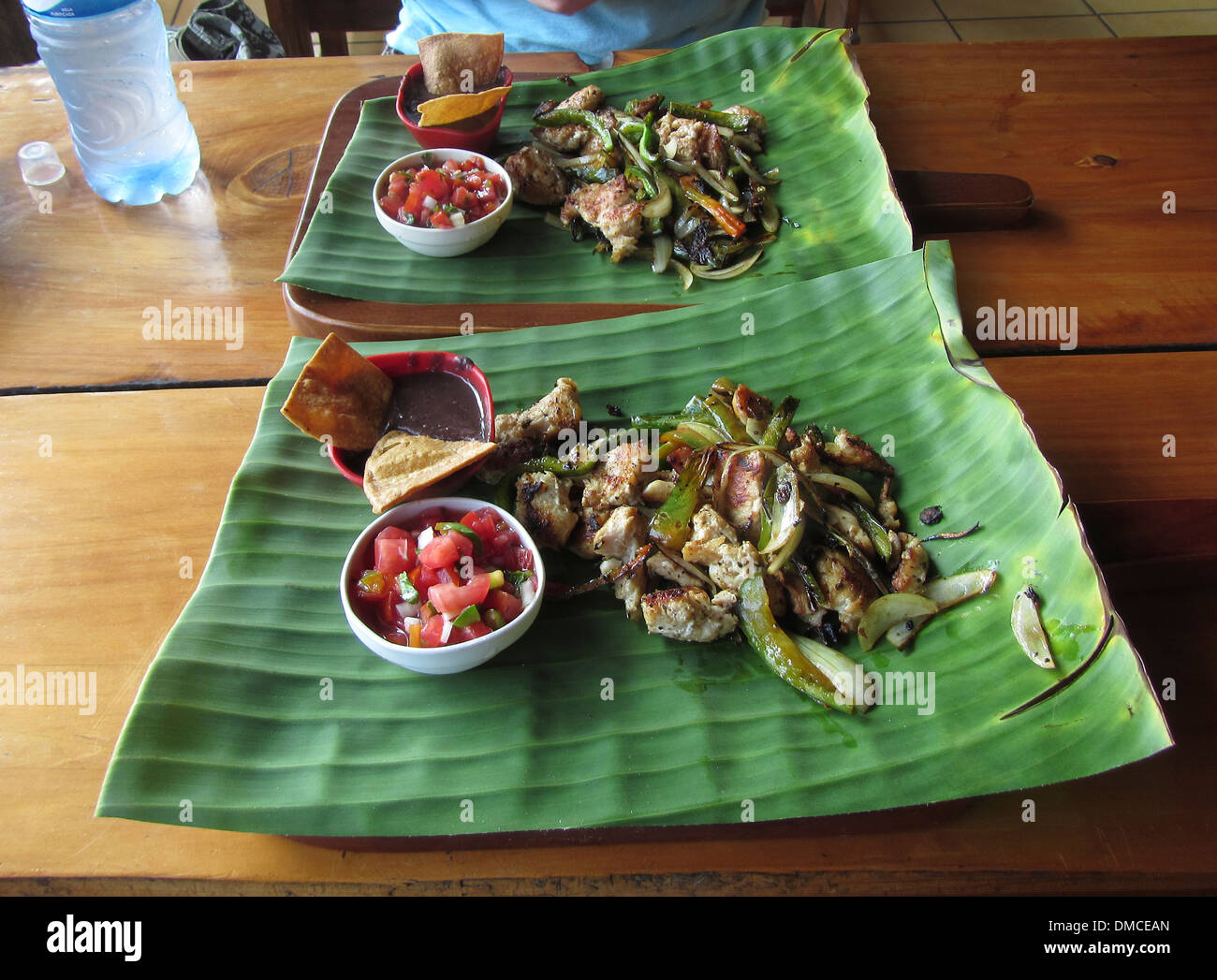 Tipico della Costa Rican servito il pranzo in un piccolo ristorante, saltate le carni e le verdure su una grande foglia di fresco. Foto Stock