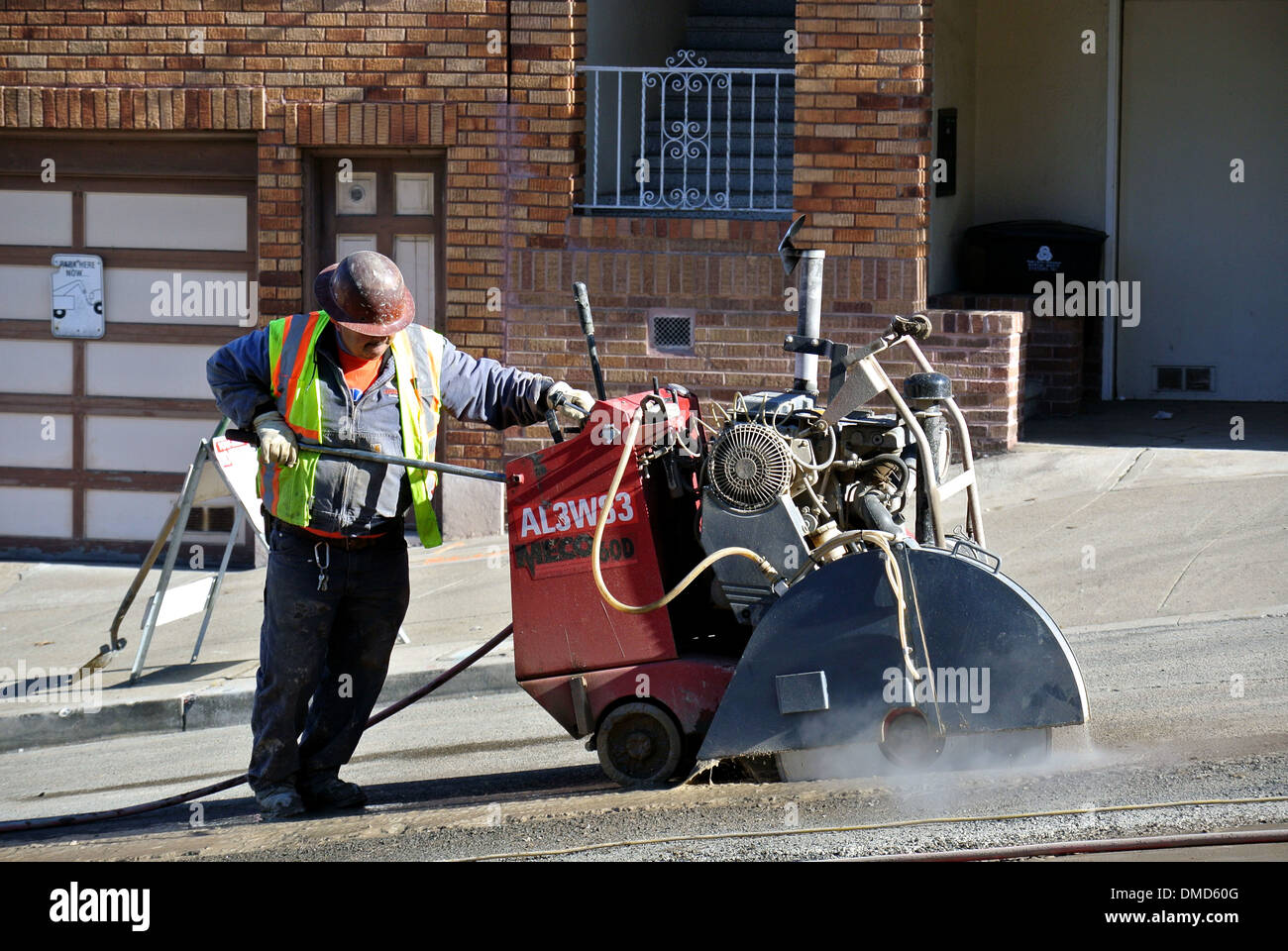 Operaio edile le linee di intagli su strada con calcestruzzo heaby sezionatrice Foto Stock