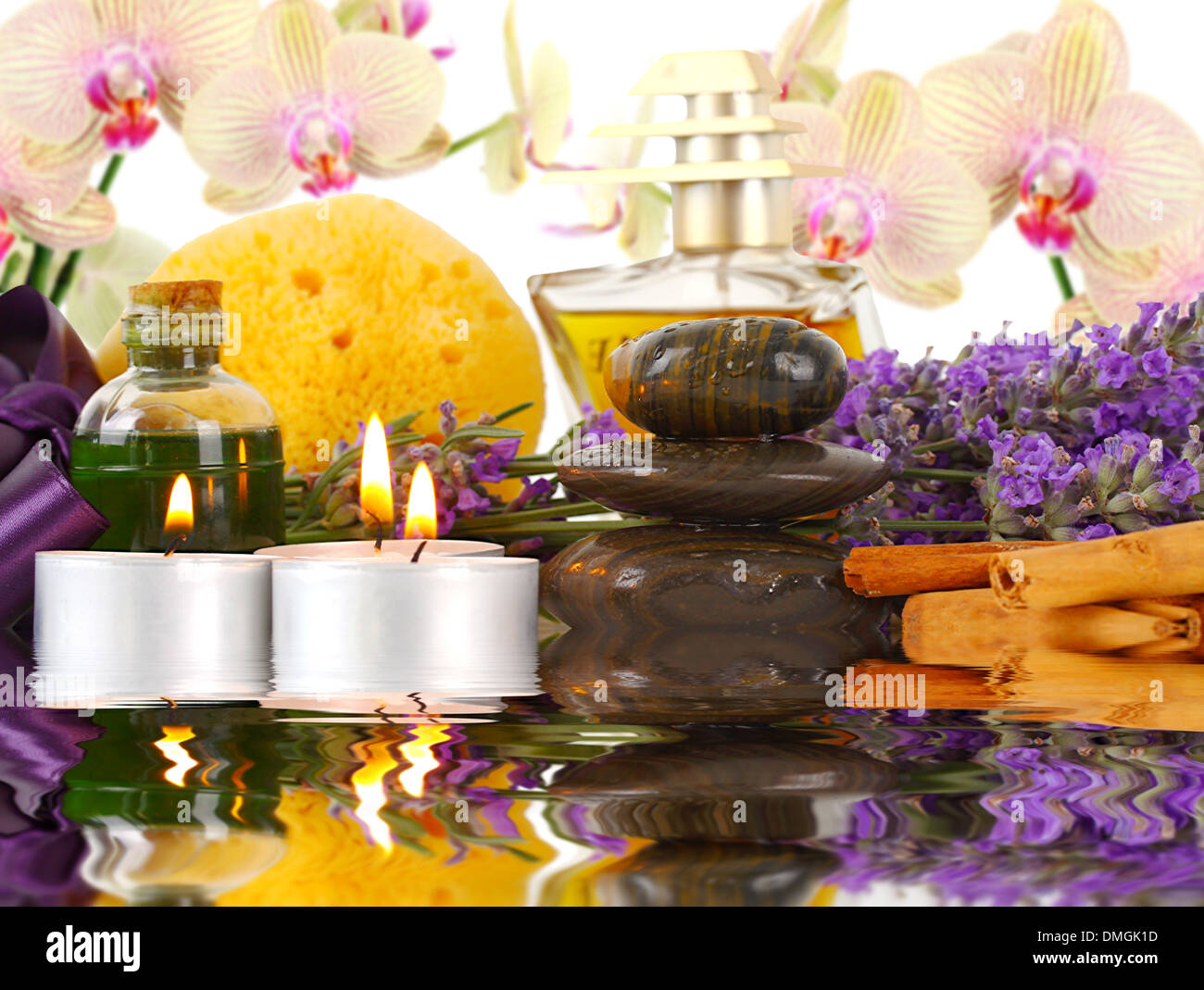 Accessori per spa con orchidee, lavanda, pietre, spugna, candele e cannella. Foto Stock