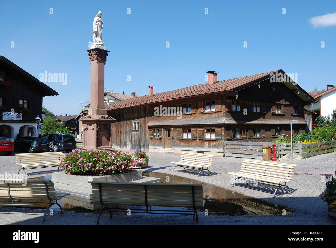 Allgaeu casa colonica del XIX secolo a Oberstaufen con la colonna mariana in primo piano. Foto Stock