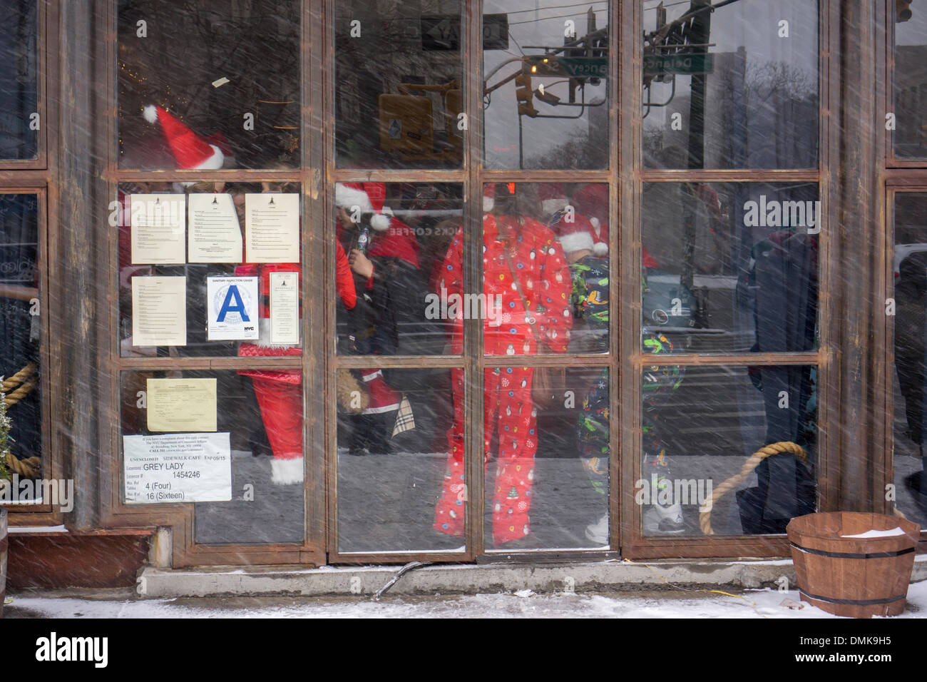 I festaioli di Natale presso il Gray Lady bar nel quartiere di Lower East Side di New York durante l annuale SantaCon Sabato, Dicembre 14, 2013. SantaCon, principalmente un pub crawl a Santa e altro Natale costumi correlati, attrae migliaia di masqueraders andando da bar a bar. I bevitori sono stati incoraggiati ad imbibire a stabilimenti che partecipano a giochi per i più piccoli. Questo anno alcune comunità si lamentano di vomito, pubblica la minzione e altri comportamenti scorretti che accompagna l'evento risultante in una polizia e repressione di transito. (© Richard B. Levine) Foto Stock