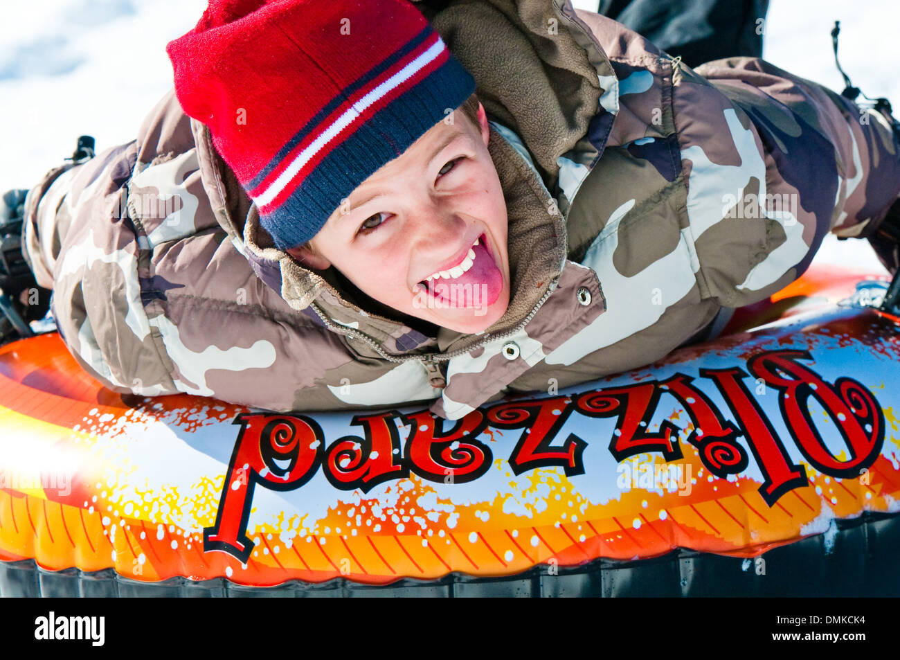 Carino boy neve Equitazione tubo fino in prossimità con la lingua fuori Foto Stock