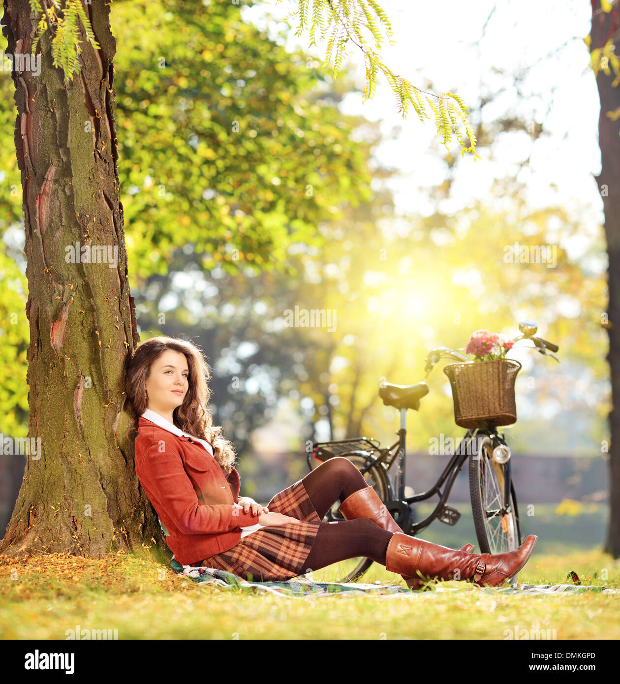 Giovane bella femmina con bicicletta rilassante in un parco in una giornata di sole Foto Stock