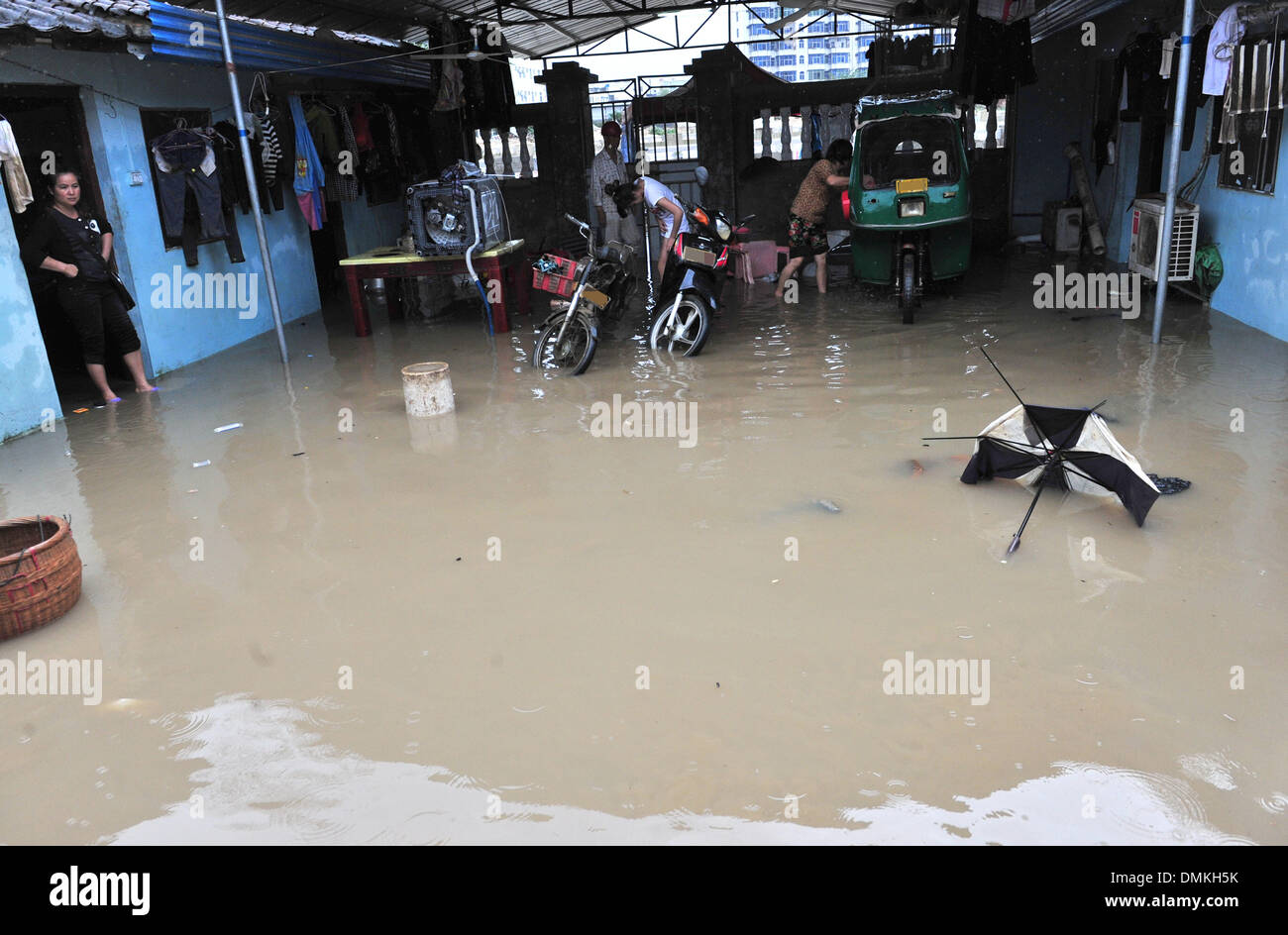 Wanning, cinese della provincia di Hainan. 15 Dic, 2013. I residenti locali pack averi a casa in una zona allagata in Wanning City, a sud della Cina di Hainan Provincia, Dic 15, 2013. Heavy Rain continua a colpire Wanning città da venerdì sera a domenica. Un totale di 80.000 residenti sono stati trasferiti alle regioni di sicuro. Credito: Zhang Yongfeng/Xinhua/Alamy Live News Foto Stock