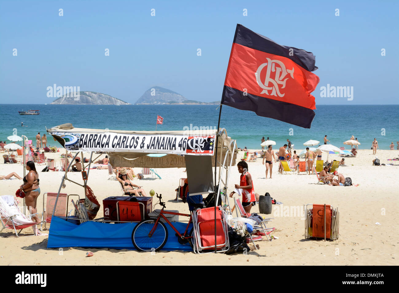 Un piccolo gruppo di tifosi di calcio con le proprie bandiere di tifosi come la Fluminense FC Flag sulla spiaggia di Ipanema a Rio de Janeiro, Brasile Foto Stock