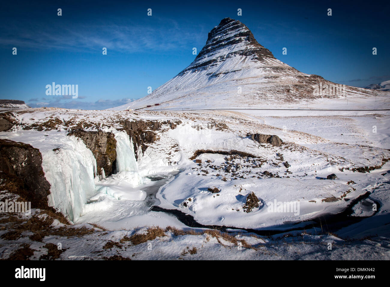 KIRKJUFELL Mountain e la cascata ghiacciata (KIRKJUFELLSFOS) visto da GRUNDARFJORDUR, BREIDAFJORDUR fiordo, SNAEFELLSNES PENINSULA, WESTERN ISLANDA, EUROPA Foto Stock