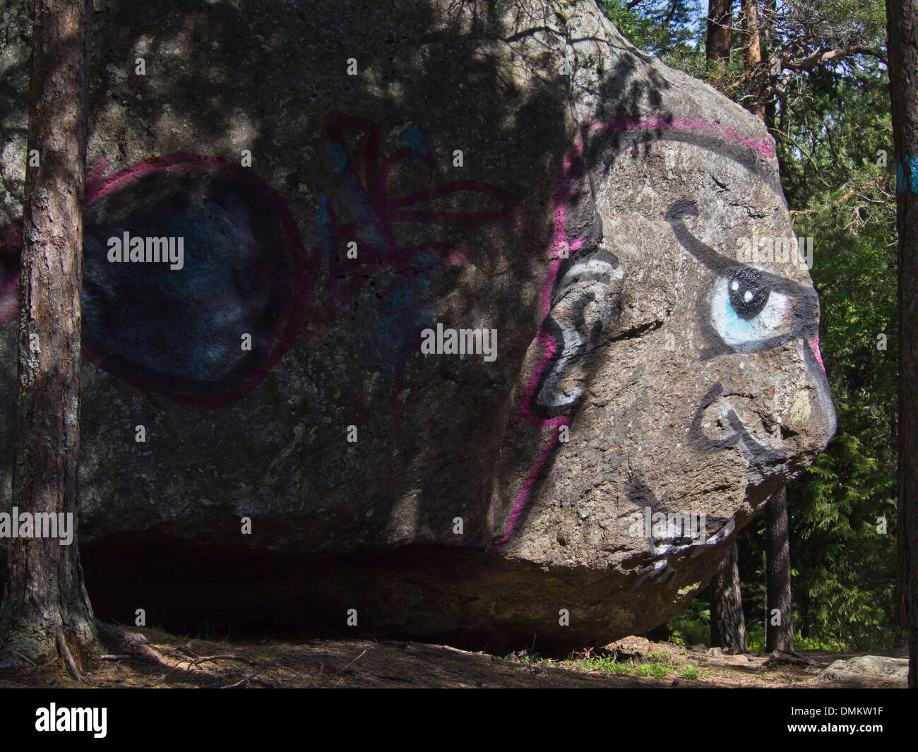 Grafitti nella foresta, dipinto di testa sfruttando la forma di una roccia, Østmarka Oslo Norvegia Foto Stock