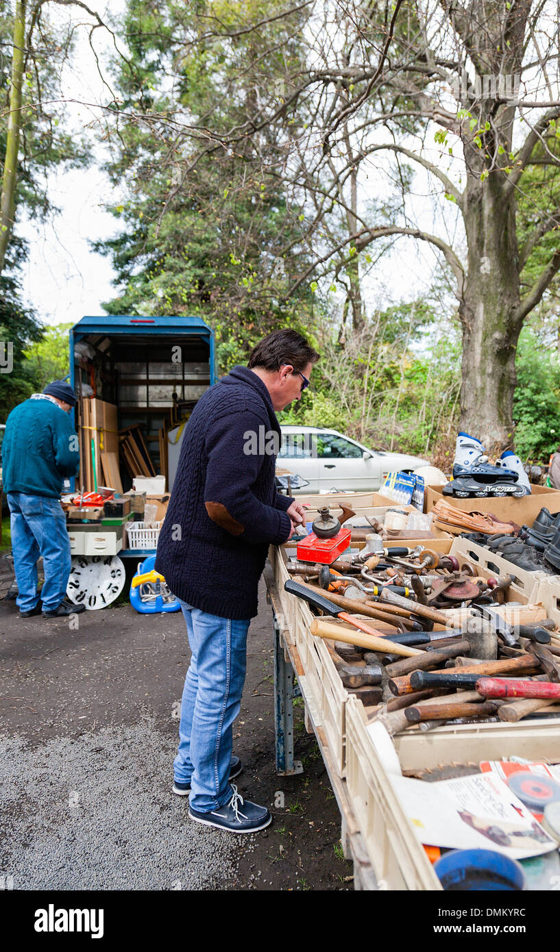 Un uomo di acquisto utilizzati, gli strumenti usati da uno stallo presso un mercato all'aperto. Foto Stock