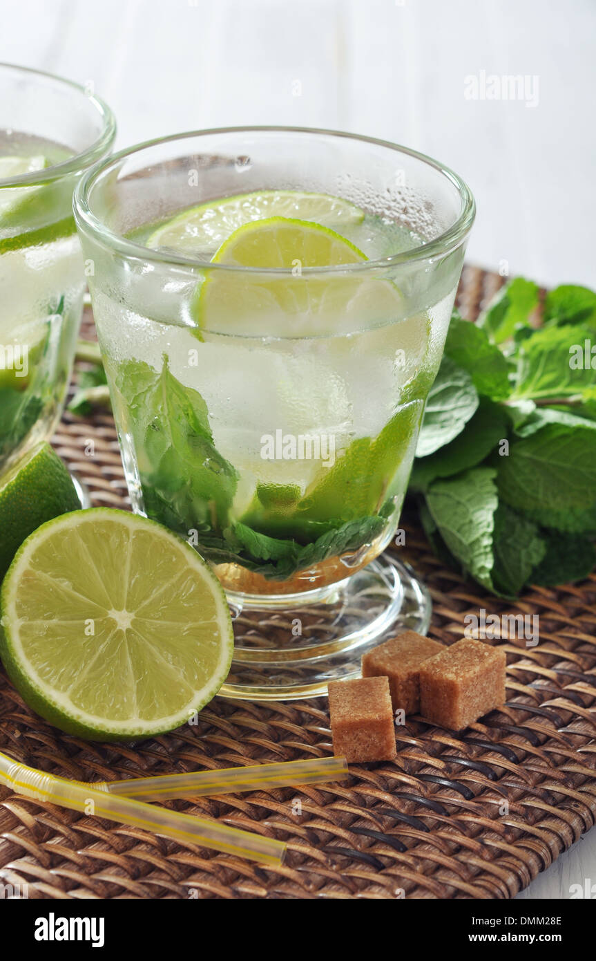 Cocktail Mojito in vetro con lime e menta sul luogo di vimini mat Foto Stock