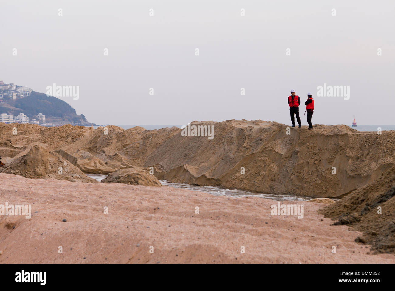 I supervisori che si affaccia su una spiaggia di progetto di bonifica del sito - Haeundae, Busan, Corea del Sud Foto Stock