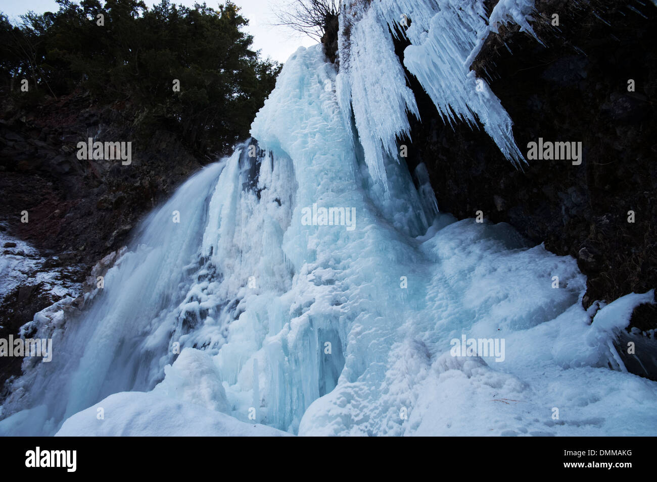Ampio angolo di guardare in su verso il semi-congelato a cascata non Zengoro Taki, Monte Norikura. Foto Stock