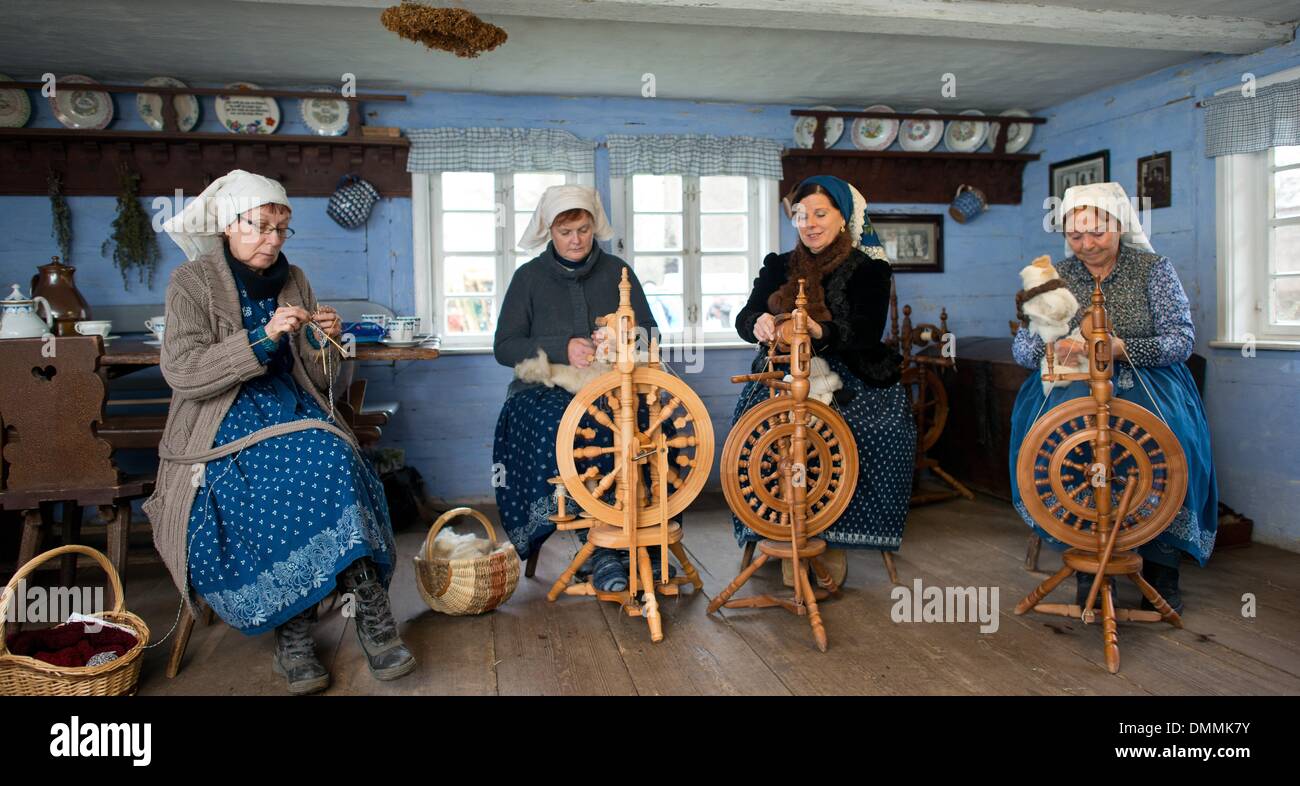 Lehde, Germania. L'8 dicembre, 2013. Le donne in abbigliamento tradizionale dalla regione Spreewald sedersi dietro le ruote di filatura lavorazione di lana di pecora in open-air museum in Lehde, Germania, 8 dicembre 2013. Il museo dispone di tre insiemi completi di Wendish fattorie che introducono i visitatori alla storia locale, i modi di vita, abbigliamento tradizionale e tipico craftswork nei locali della regione Spreewald. Foto: Patrick Pleul/ZB/dpa/Alamy Live News Foto Stock