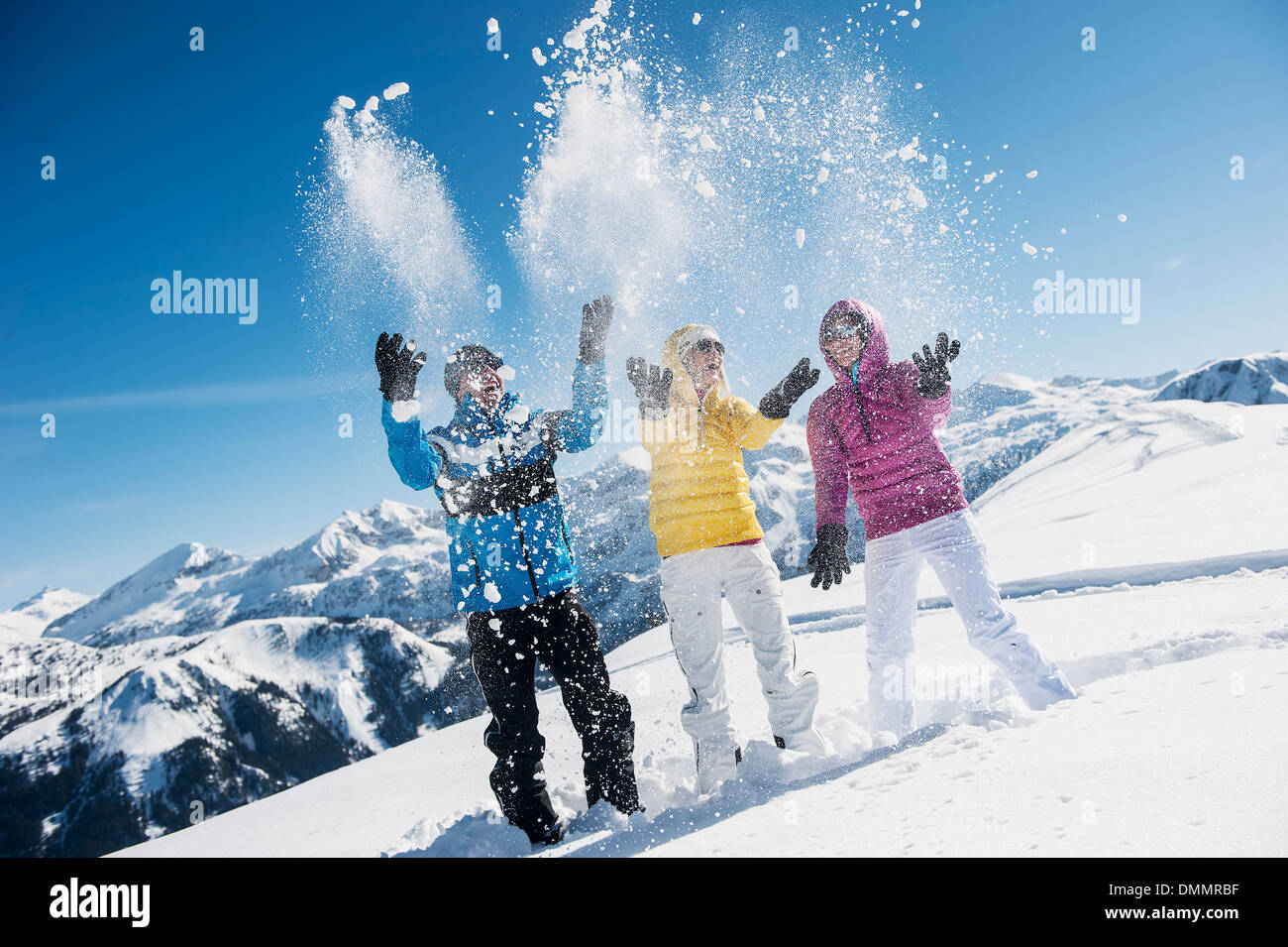 Austria, Salisburgo, giovane e giovani donne gettando di neve con gli sci Foto Stock