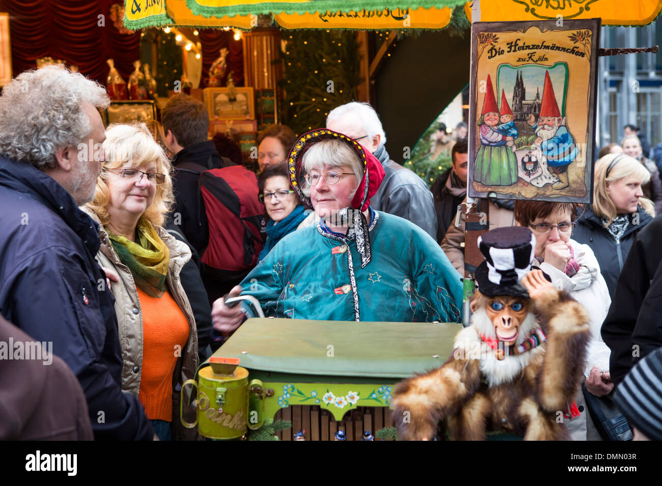 Mercatino di Natale di Colonia, donna con costume tradizionale e organetto all'(Altstadt o la parte vecchia della città) Foto Stock