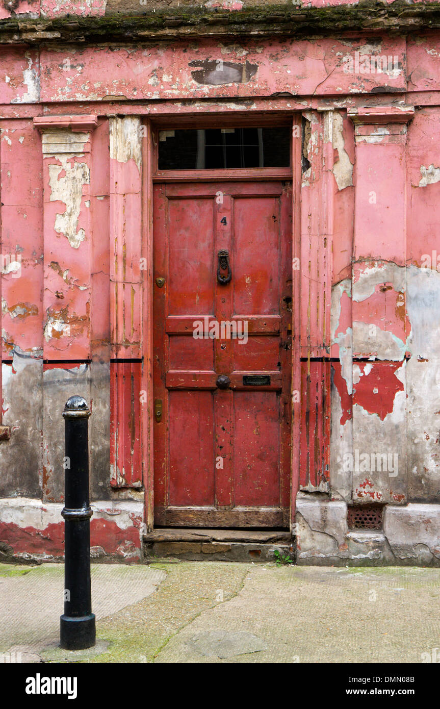 La porta anteriore di un peeling e fatiscente casa cercando in Princelet Street, Spitalfields. Foto Stock