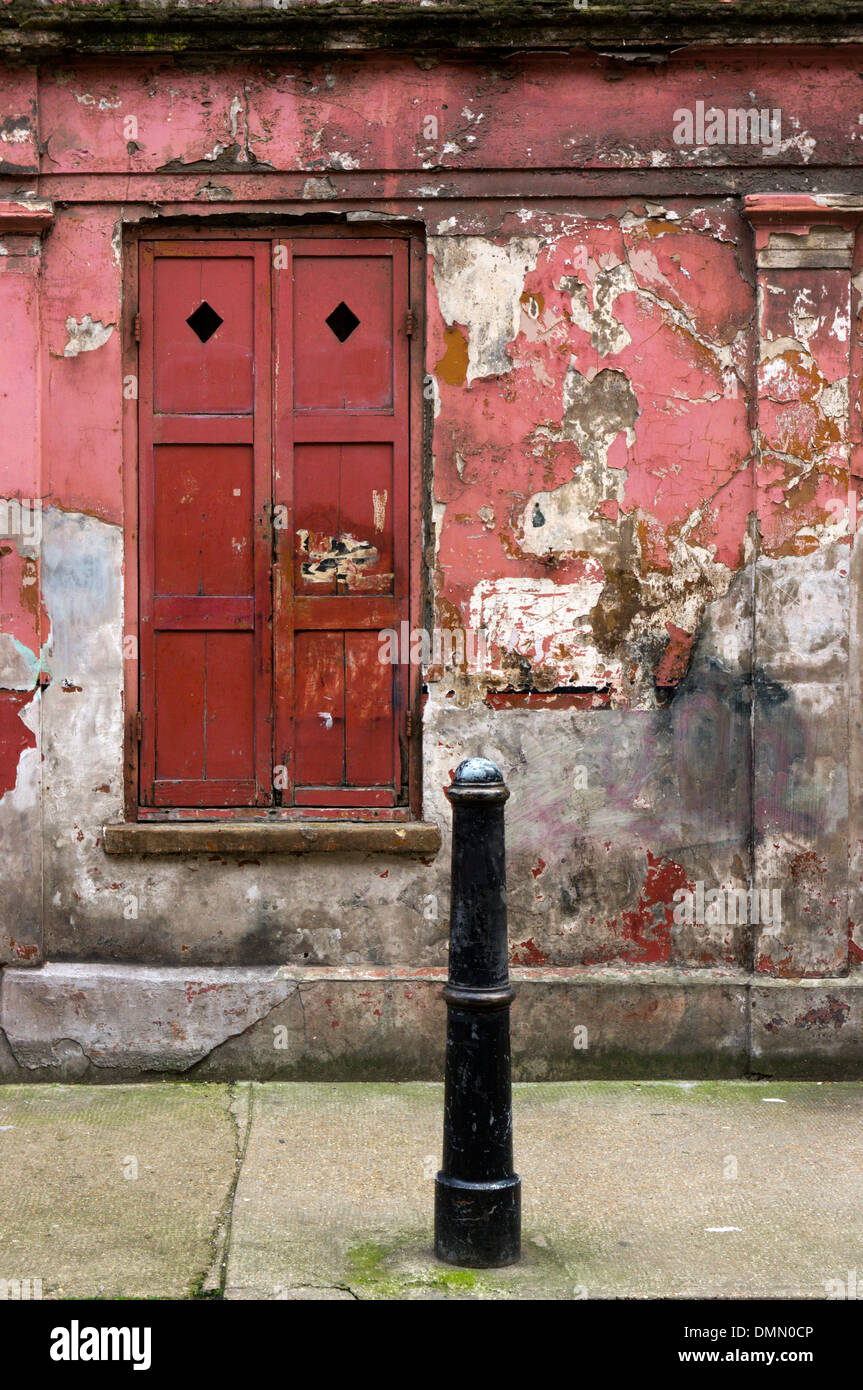 Finestra e persiane di un peeling e fatiscente casa cercando in Princelet Street, Spitalfields. Foto Stock