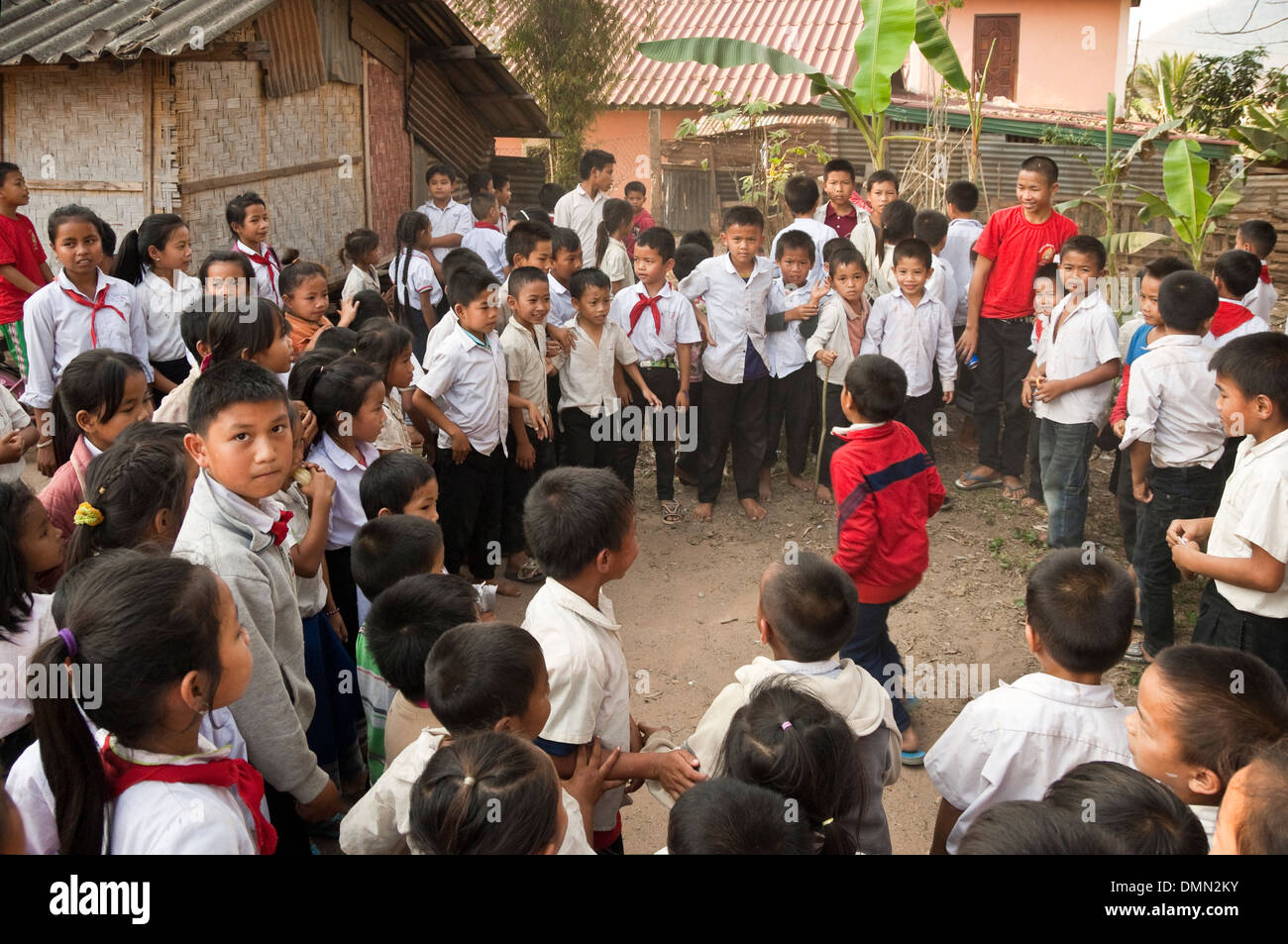 Vista orizzontale di un sacco di bambini in età scolare in un cerchio di suonare insieme ad una scuola in Laos. Foto Stock