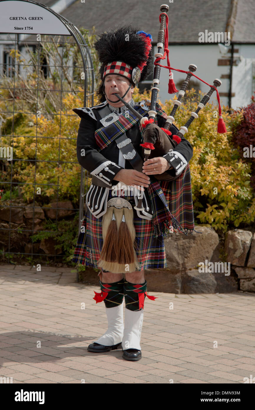 Scottish piper presso il vecchio fabbro del negozio a Gretna Green Dumfries And Galloway, Scozia, Gran Bretagna Foto Stock