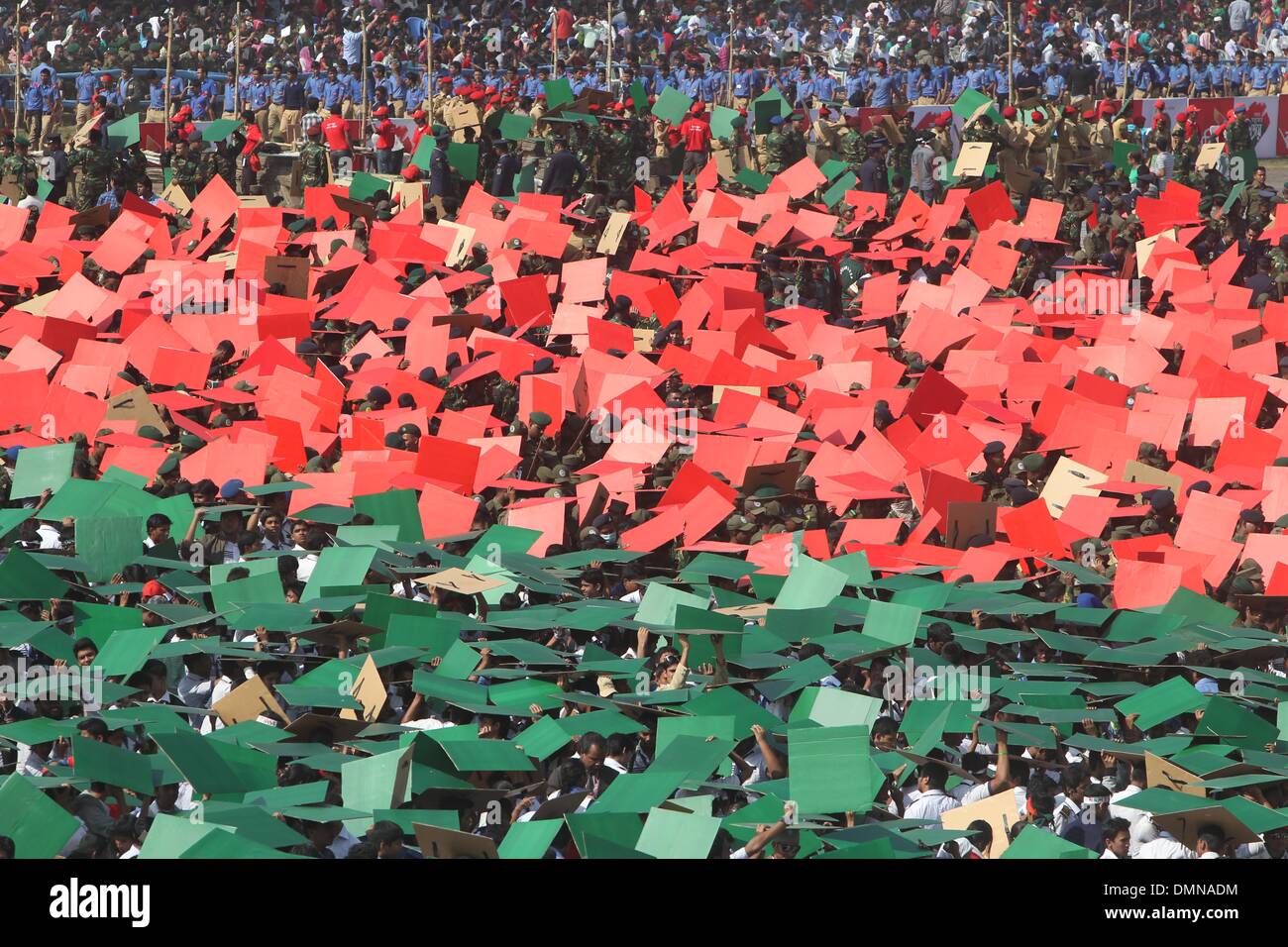 Dacca in Bangladesh. Xvi Dec, 2013. I membri dell'esercito del Bangladesh, della difesa dei funzionari e degli scolari formano il più grande del mondo umano bandiera nazionale per il marchio del paese la vittoria di giornata a Dhaka il 16 dicembre 2013. Un totale di 27,117 volontari, soprattutto studenti, utilizzate piastrelle colorate per formare la bandiera a Dhaka nazionale della parata a terra. Il Bangladesh ha vinto l'indipendenza dal Pakistan dopo un amaro nove mesi di guerra nel 1971 ha portato da parte del paese di fondatore Sheikh Mujibur Rahman, e questo viene celebrata ogni anno il 16 dicembre. Credito: Monirul Alam/ZUMAPRESS.com/Alamy Live News Foto Stock