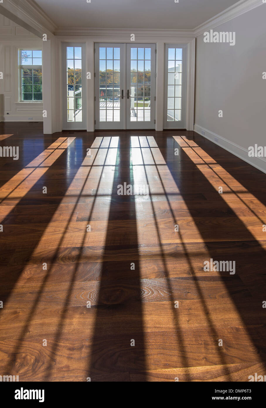 Lunghe ombre sul pavimento in legno nella camera a vuoto Foto Stock