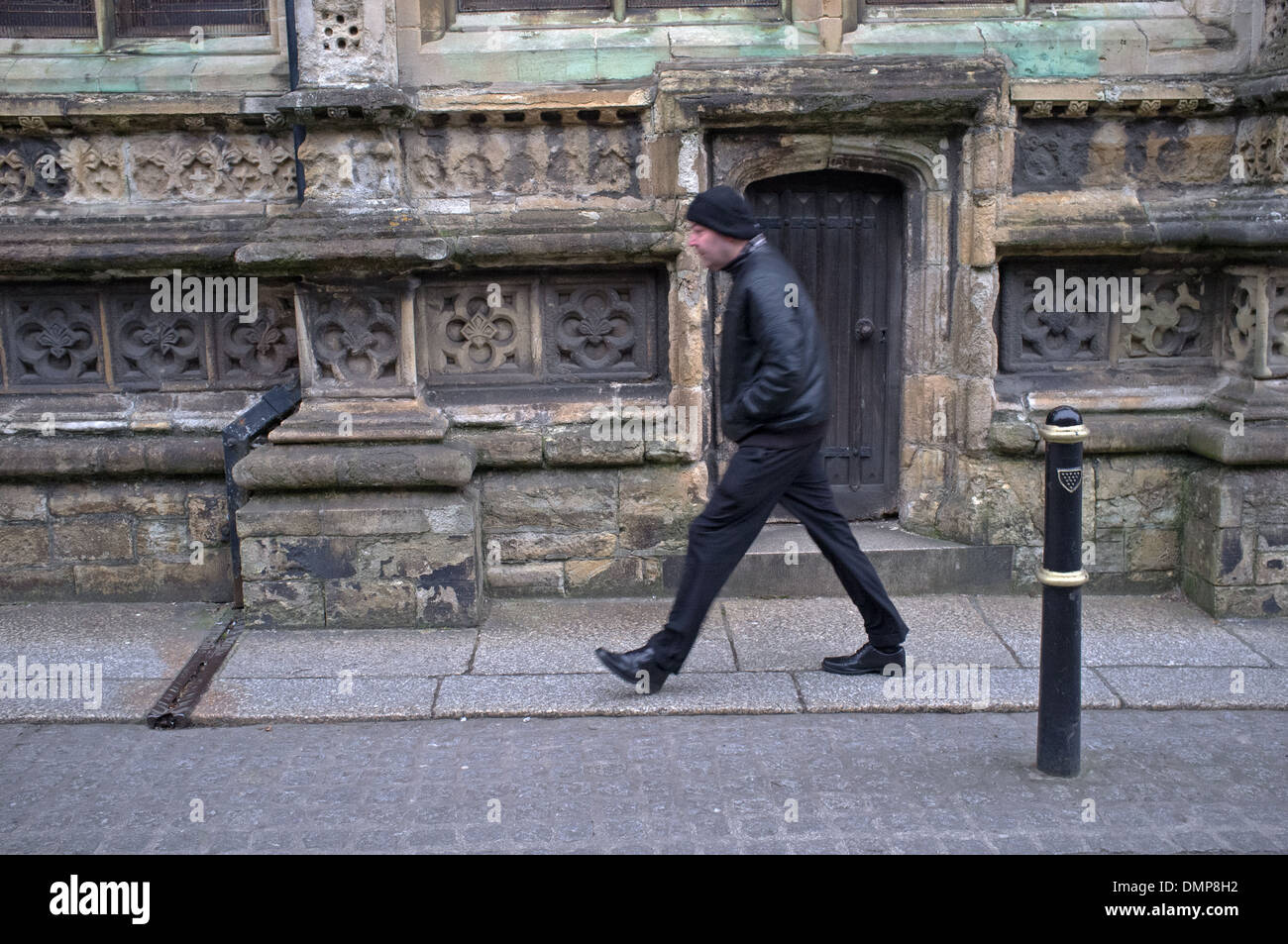 Un freddo e ventoso giorno in Truro, Cornwall.Un uomo cammina passato Truro Cathedral Foto Stock