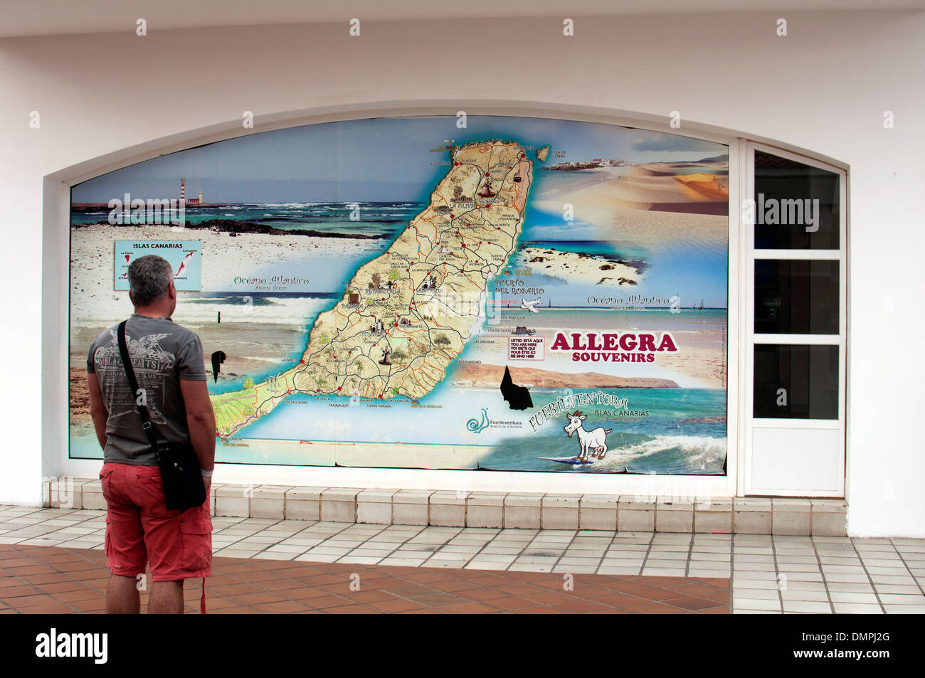 Uomo che guarda la mappa di Fuerteventura su una parete, Caleta de Fuste, Fuerteventura, Isole Canarie. Foto Stock