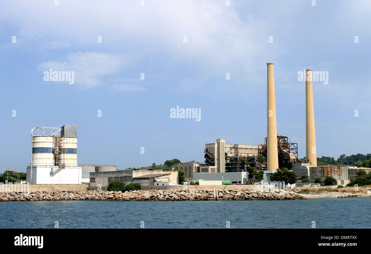 Stabilimento industriale con grande ciminiera vista dall'oceano. Foto Stock