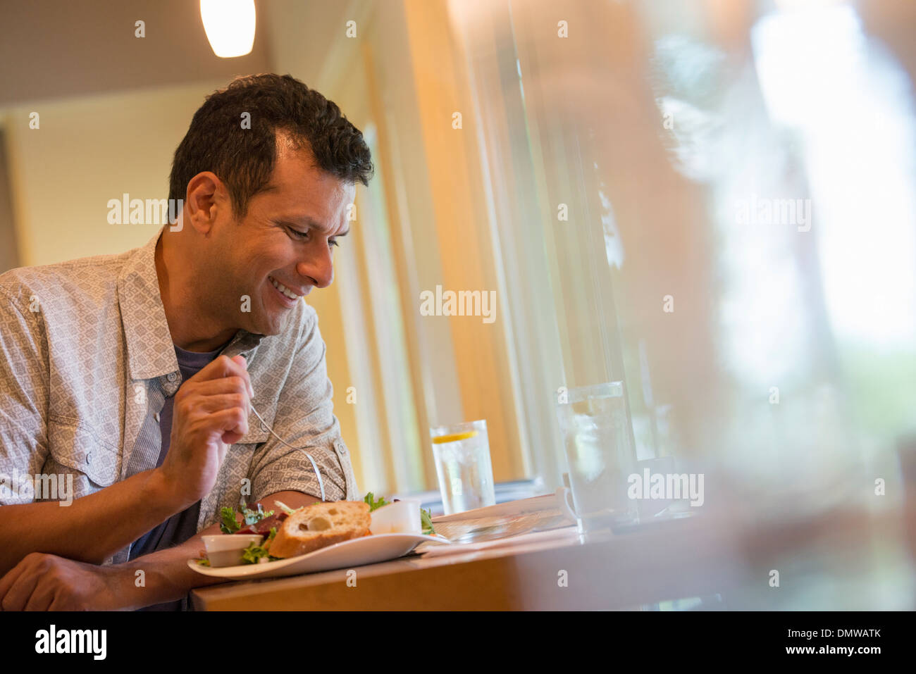 Un uomo di mangiare uno spuntino in un bar. Foto Stock