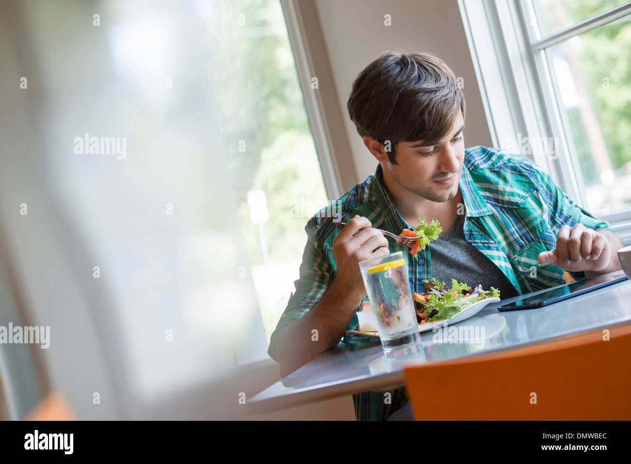 Un giovane uomo che utilizza una tavoletta digitale. Foto Stock